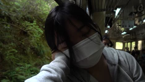 Japanisches-Mädchen-Mit-Corona-gesichtsmaske,-Das-Auf-Fahrendem-Zug-Schläft