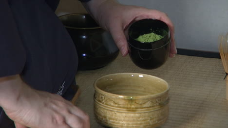 Matcha-tea-is-scooped-into-a-tea-bowl-during-a-Japanese-tea-ceremony-known-as-"chanoyu