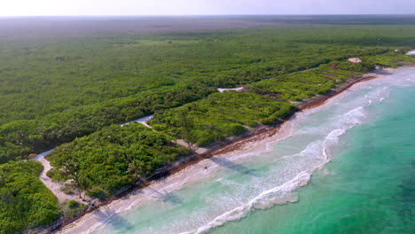 Wide-cinematic-rotating-drone-shot-of-natural-coastline-near-Mahahual-Mexico-into-the-sun