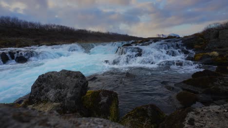 Static-wide-shot-of-Hlauptungufoss-Waterfall-Stream-during-cloudy-day-and-sunlight-in-Iceland