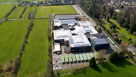 Aerial-of-large-high-school-surrounded-by-green-meadows
