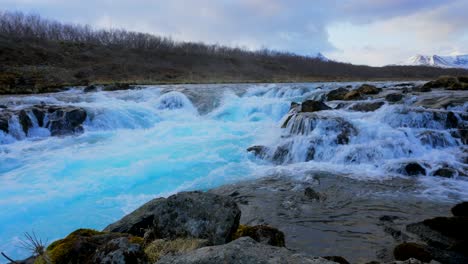 Ice-blue-colored-water-flooding-cascade-waterfall-and-stream-during-daytime