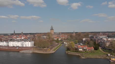 Countenance-aerial-view-of-pleasure-boat-harbor-and-traffic-along-and-on-the-cityscape-boulevard-of-Zutphen-with-Walburgiskerk-cathedral-towering-behind-and-reinforced-wall-in-foreground
