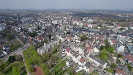 Bochum-Wattenscheid-skyline-on-a-sunny-day,-aerial-drone-pull-back-shot
