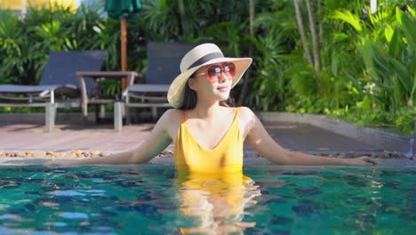 Frau-Mit-Sonnenhut-Trägt-Gelben-Badeanzug-Und-Entspannt-Sich-Im-Pool