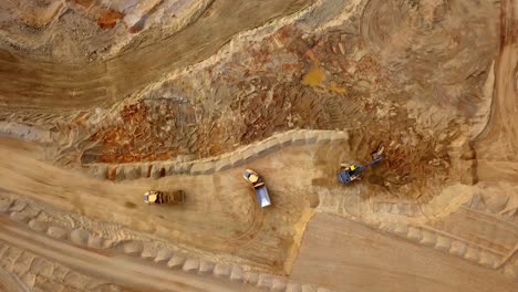 Aerial-View-of-Rock-Quarry-Excavation-Bulldozer-and-Trucks-are-Loading-Rocks