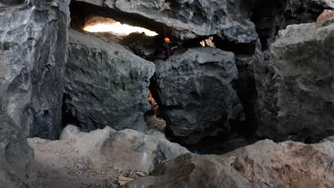 Rock-climber-climbing-cave-rock-interior,-Asian-karst-mountain-caves