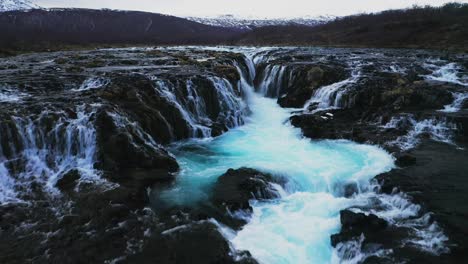 Luftüberführung-Schönes-Blaues-Gletscherwasser-Des-Flusses,-Das-Fließt-Und-Den-Bruarfoss-Wasserfall-In-Island-Hinunterfällt