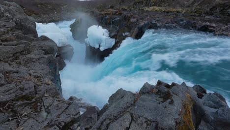 Strong-And-Powerful-Flow-Of-Blue-Water-In-Rocky-Surface-Of-Hlauptungufoss-Waterfall-In-River-Bruara,-Iceland---drone-shot