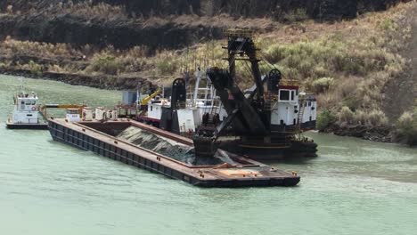 Excavadora-Flotante-Cargando-Una-Barcaza-En-El-Lago-Gatún,-Canal-De-Panamá
