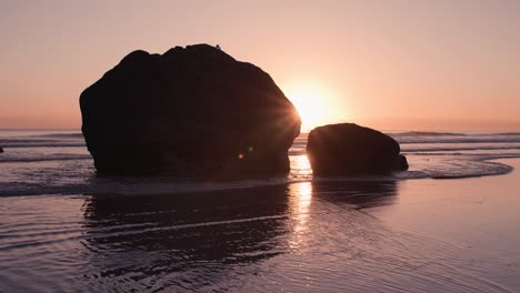 Silhouette-Großer-Felsbrocken-Mit-Sonne,-Die-Bei-Farbenfrohem-Sonnenaufgang-Dahinter-Bricht