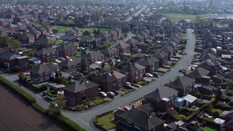 Countryside-housing-estate-aerial-view-flying-above-England-farmland-residential-rural-homes-dolly-right