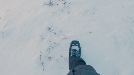 Male-hiker-walking-in-deep-snow-with-snowshoes-on