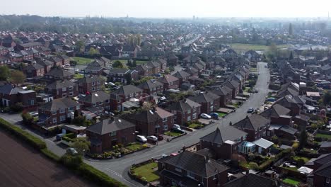 Countryside-housing-estate-aerial-view-flying-above-England-suburb-farmland-residential-homes-push-forwards