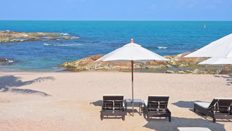 Liegestühle-Und-Sonnenschirme-Am-Tropischen-Strand-Mit-Blauem-Ozean