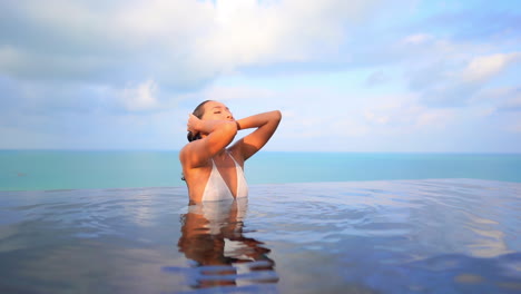 Sexy-Asiatische-Frau,-Die-Sich-Im-Schwimmbad-Entspannt,-Meerblick-Hintergrund-Slomo