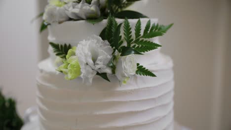 Wedding-Cake-with-White-Frosting-and-Flower-Arrangement-Decor---Close-up