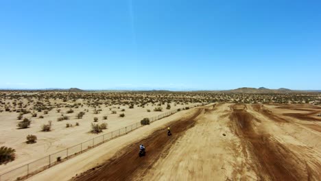 High-speed-off-road-motorcycle-race-on-a-desert-dirt-course---slow-motion-aerial-view