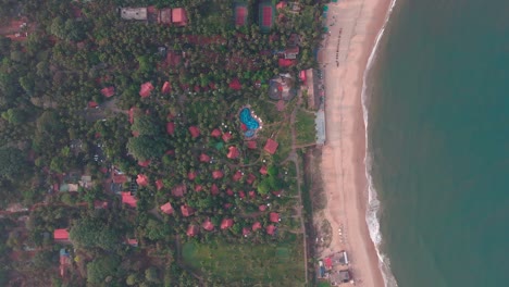 Goa-Sinquerim-Beach-Drohnenaufnahme-Hüttenansicht-Vom-Strand-Zu-Den-Wellen-Top-Vogelperspektive-Extreme-Top-Filmische-Villa-Hotel-Am-Strand