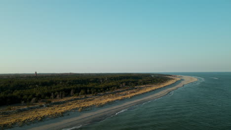 Distant-Lighthouse-On-Lush-Vegetation-At-Hel-Peninsula-Beach-In-Baltic-Sea,-Poland