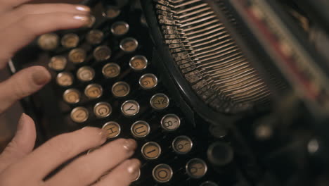 Top-down-shot-of-woman's-hands-typing-on-vintage-typewriter---slide-across-keys
