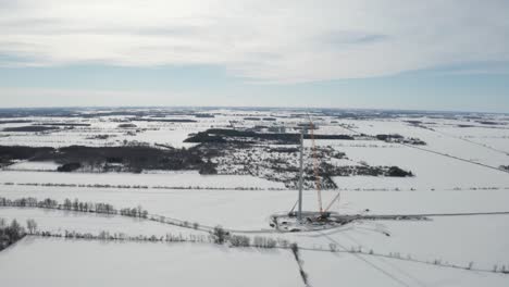 Flat-snowy-plains-and-construction-of-wind-energy-tower-for-green-power-generation