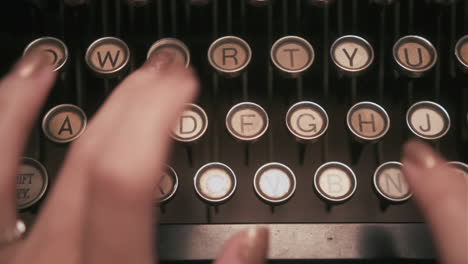 close-up-top-down-shot-of-hands-typing-on-mechanical-typewriter-keys---dolly-left-to-right