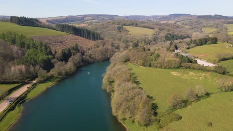 4K-flying-over-hawkridge-reservoir,-drone-moving-forward-over-the-water-and-over-a-trout-fishing-boat,-60fps