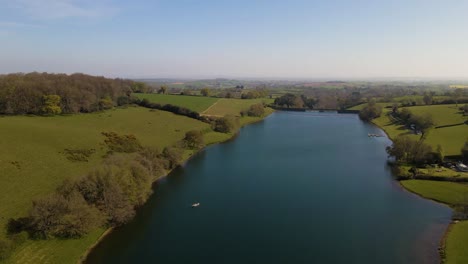 4K-flying-over-hawkridge-reservoir,-drone-raising-over-the-water-revealing-the-fishing-boats-docks-and-the-water-dam-wall,-60fps