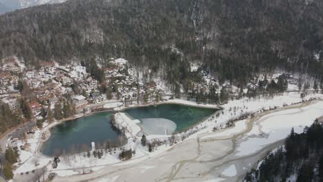 Lago-Alpino-En-Invierno-Cubierto-De-Nieve-Y-Bosque-En-Segundo-Plano.