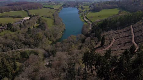 4K-flying-over-hawkridge-reservoir,-drone-moving-forward-over-the-trees-towards-to-the-water-reservoir,-60fps