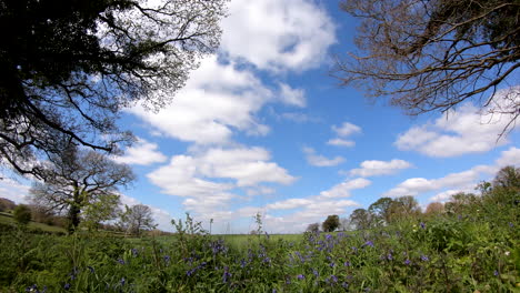 A-time-lapse-of-a-spring-sky-flowing-over-green-fields-and-hedgerows-in-Worcestershire,-England