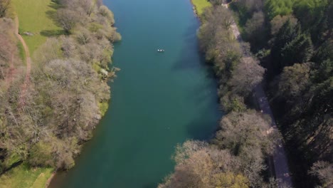 4K-flying-over-hawkridge-reservoir,-drone-moving-forward-over-the-water-and-over-a-trout-fishing-boat,-60fps