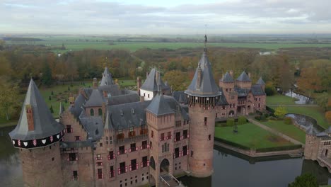 Aerial-at-Castle-De-Haar,-flying-past-bronze-statue-on-top-of-main-tower