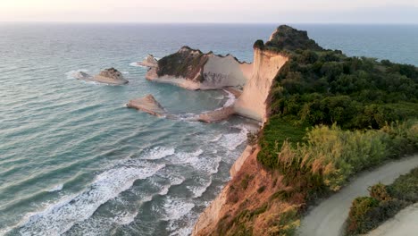 Flying-over-the-edge-of-Cape-Drastis-with-waves-crushing,-Corfu,-Greece