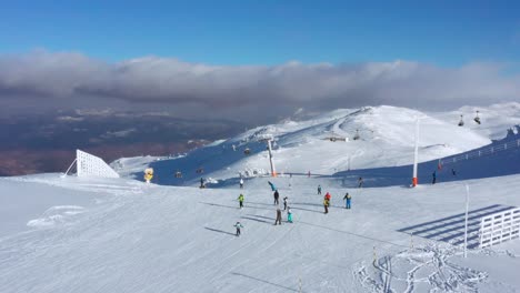 4K-aerial-of-skiers-on-Jahorina-mountain-in-winter-snow,-Bosnia-and-Herzegovina