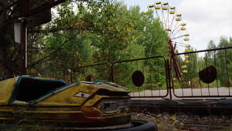 Yellow-bumper-car-in-zoom-in-view-with-Ferris-wheel-in-background,-Pripyat