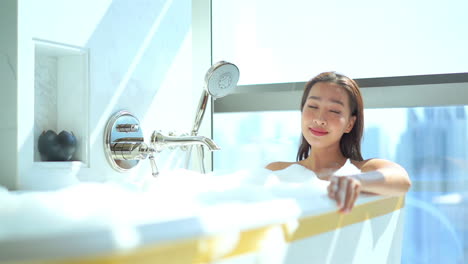 Schöne-Und-Sinnliche-Asiatische-Junge-Frau,-Die-In-Der-Luxusbadewanne-Des-Hotelzimmers-Badet-Und-Sich-Entspannt