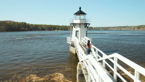 Woman-walking-along-Lighthouse-Walkway-at-Doubling-Point-Lighthouse,-Arrowsic,-Maine,-USA