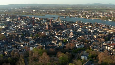 Mainz-Drone-Shot-with-the-Cathedral-church-in-the-middle-of-old-town-with-the-blue-Rhine-river-in-the-back