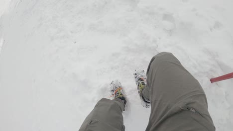 Walking-downhill-in-crampons-and-ice-axe-in-hand---hiking-snowy-trails-in-tatra-mountains