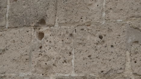 Panning-over-bullet-holes-in-old-Church-wall-in-Oosterbeek,-the-Netherlands