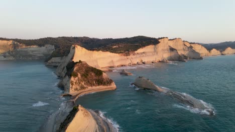 Aerial-low-approach-at-Cape-Drastis-at-golden-hour,-Corfu,-Greece