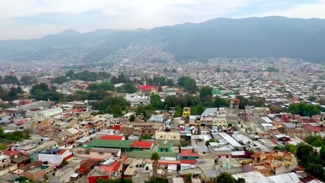 Revealing-drone-shot-of-San-Cristobal-de-las-Casas-Mexico,-streets-and-buildings