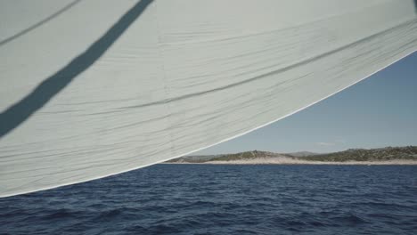 Sailing-in-croatia,-Sail-in-front-of-clear-blue-water-and-an-island