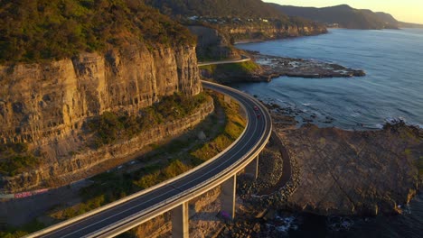 Cars-Travelling-At-Sea-Cliff-Bridge-On-A-Sunny-Sunrise-At-Coalcliff,-NSW,-Australia