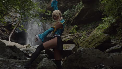 Lucy-Heartfilia-Anime-Kostüm-Cosplayer-Genießt-Die-Natur-Mit-Einem-Erstaunlichen-Wasserfall-Im-Hintergrund