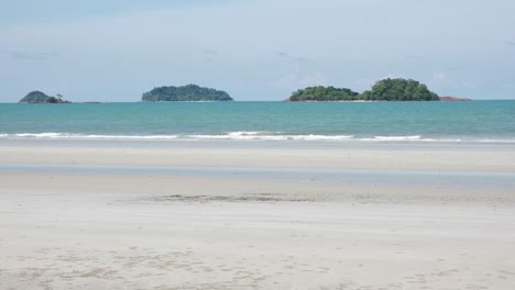 Tropical-white-sand-beach-with-ocean-and-far-away-islands