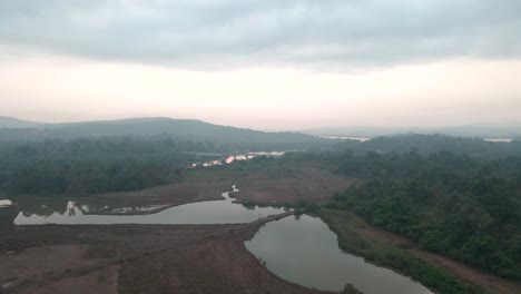 train-passing-by-a-bridge-over-the-river-in-goa-India-divar-island-drone-shot-sunset-rise