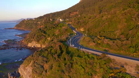 Sunrise-View-Of-The-Sea-Cliff-Bridge-At-The-Edge-Of-New-South-Wales-Coast-In-Australia---aerial-shot